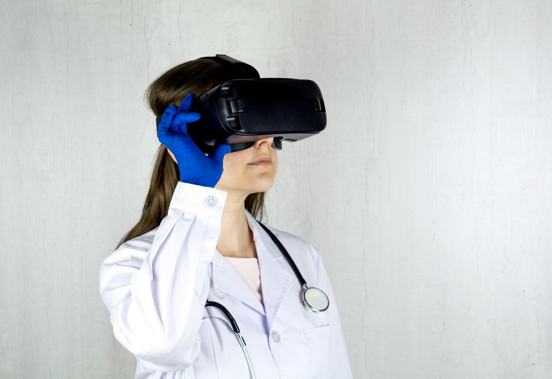 woman in white coat wearing blue and black vr goggles